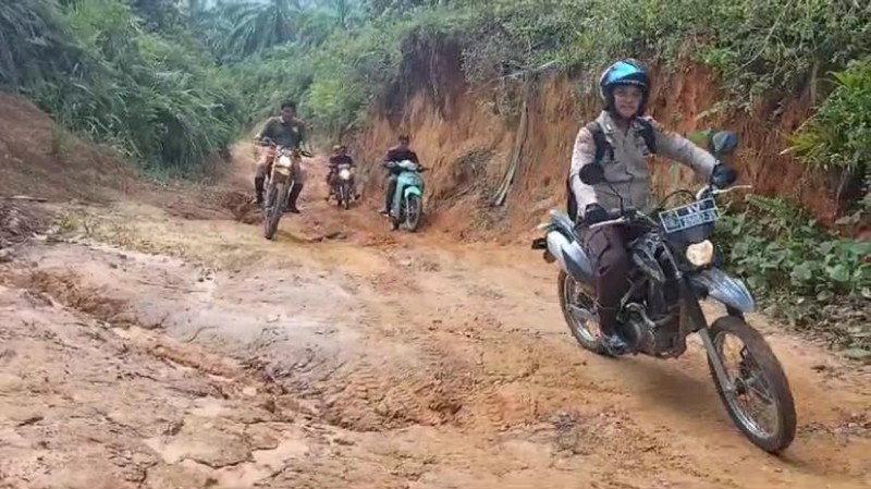 Kapolsek Tandun Berjibaku Lewati Jalan Berlumpur Demi Sampaikan Pesan Pilkada Damai kepada Masyarakat