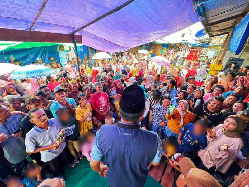 Hujan, Warga Belaras Tetap Padati Kampanye Fermadani Meski Pakai Payung